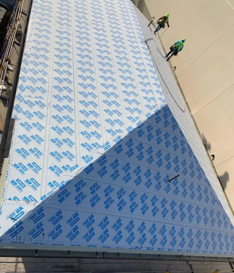 Professional roofers installing underlayment on a metal roof in Solvang